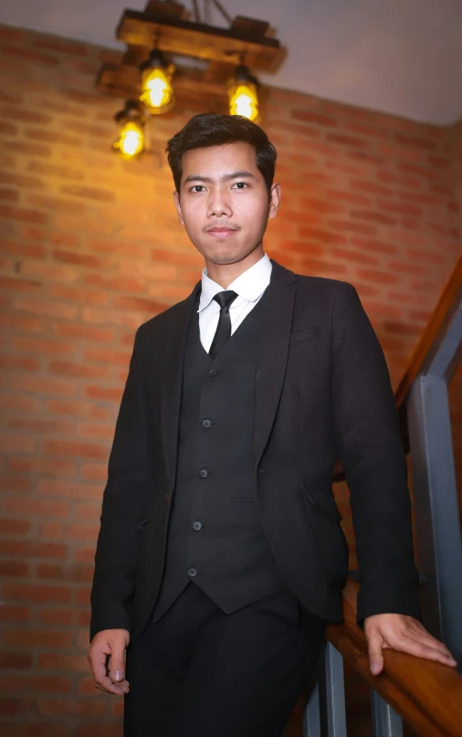 a man in a suit is standing on a stair rail