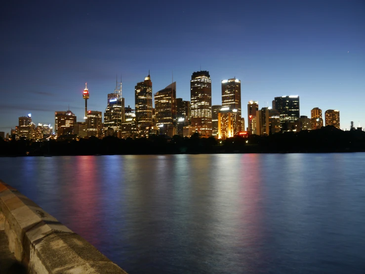 a large city skyline at night over a body of water