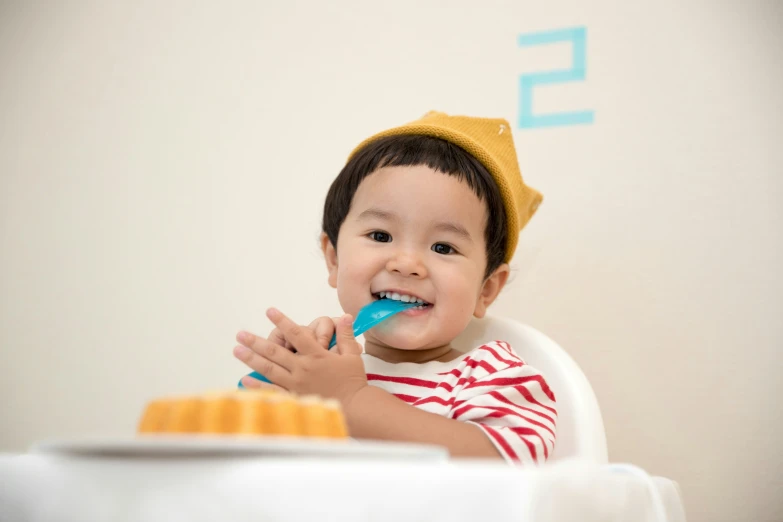 a child sits in a chair and brushes his teeth