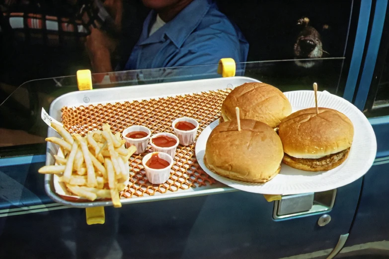 two hamburgers and fries are on a tray