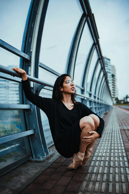 a woman that is kneeling down near some rails