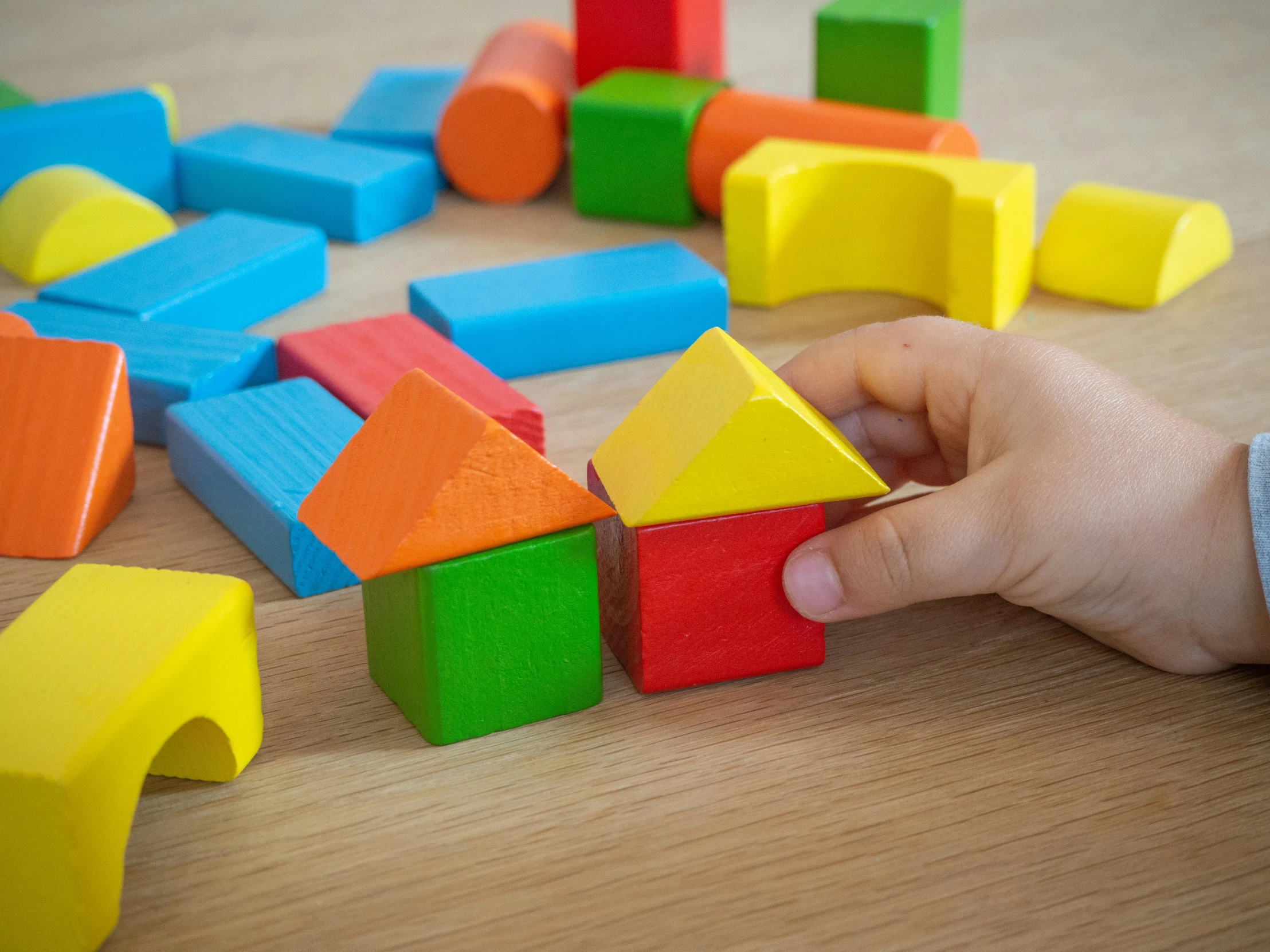 a hand that is holding a building block toy