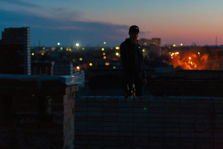 a man standing on top of a roof looking at the camera