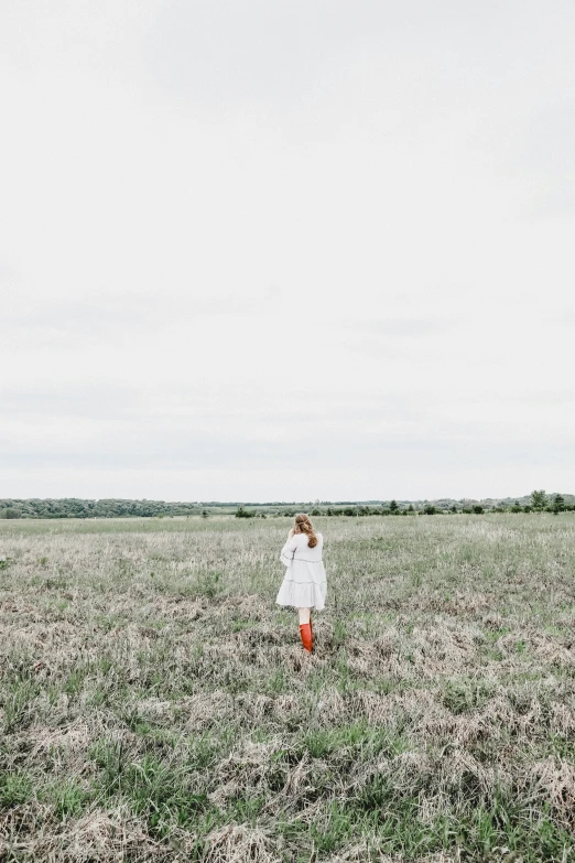 a young person in a field near a tree