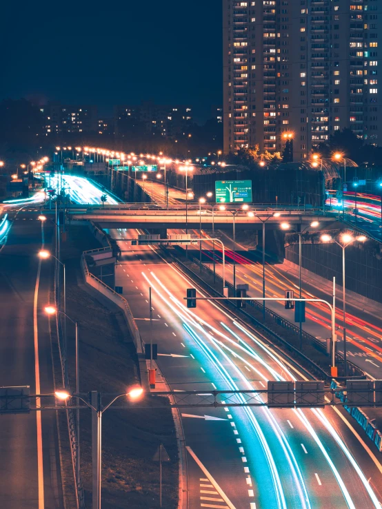 a highway with several lanes and freeway signs at night