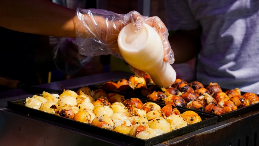 someone cooking on a big metal pan filled with food