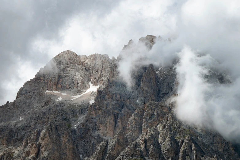 a very large mountain surrounded by clouds and trees