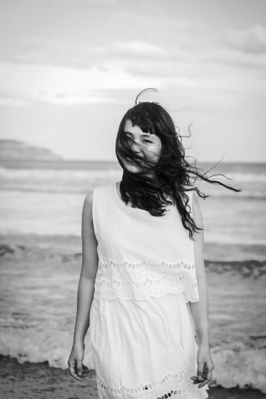 the girl is standing in front of a body of water