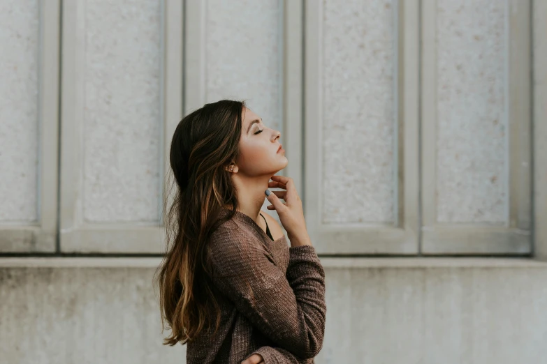 a woman is wearing a sweater and talking on a phone