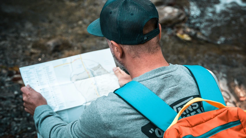 a man standing outside holding a map