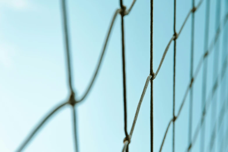 close up of a wire fence against a blue sky