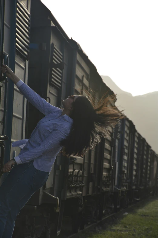 a woman leaning out the side of a train