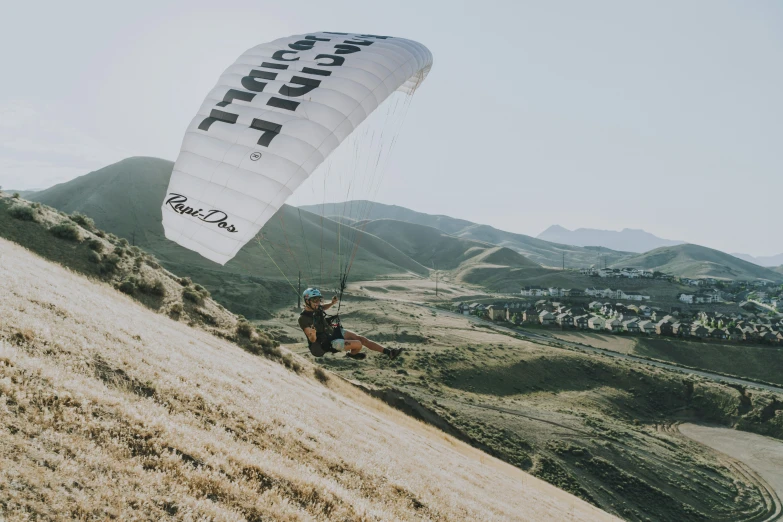 a man in blue helmet hanging from the side of a parachute