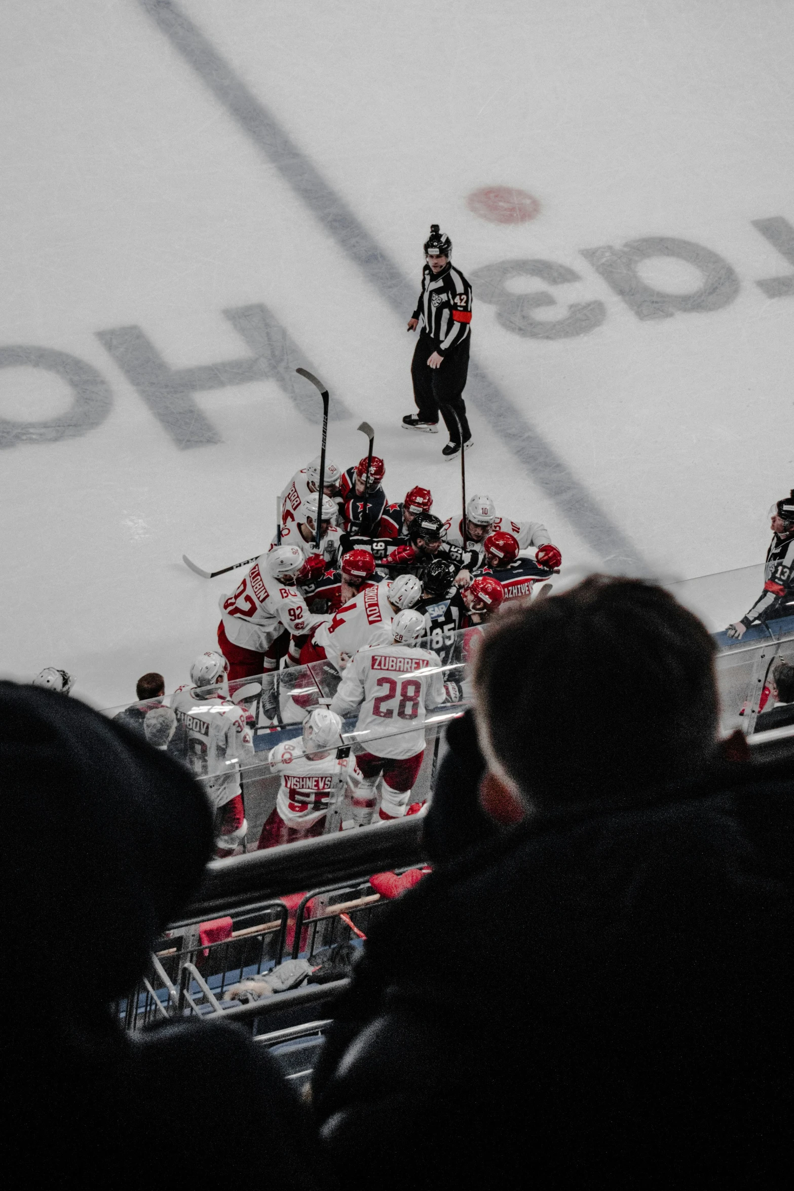 several people watching an athletic game with a referee in the background