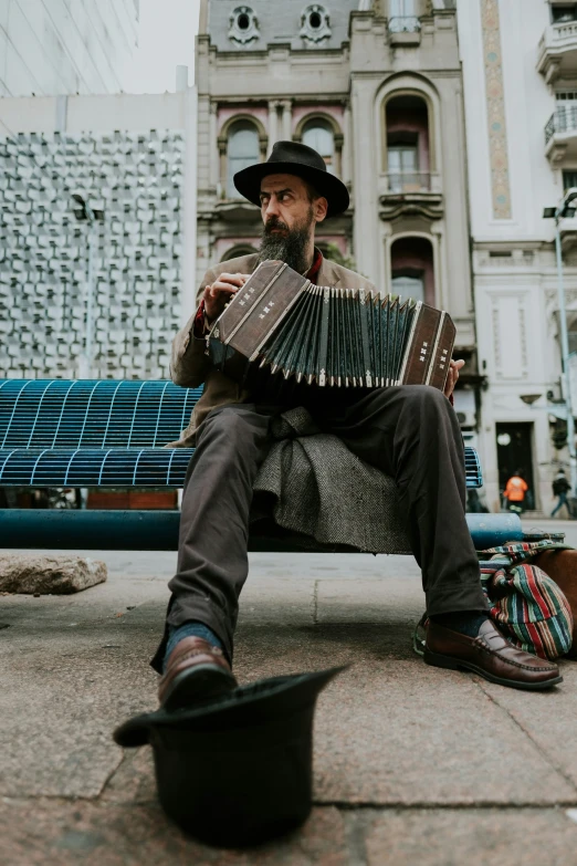 a man sitting on top of a bench holding an accordion