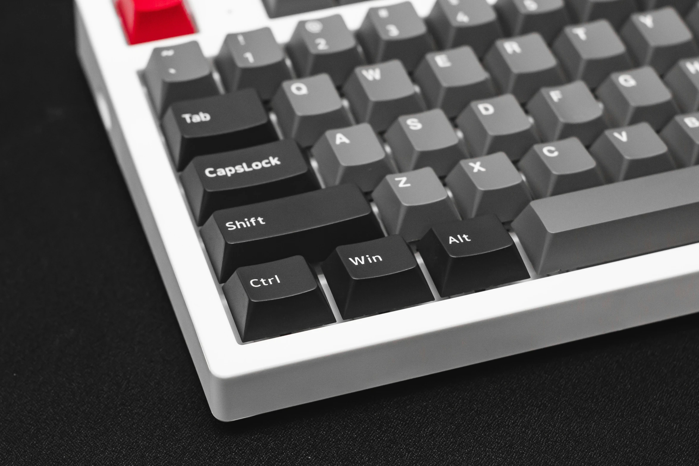 a close up of a computer keyboard that has the red light on