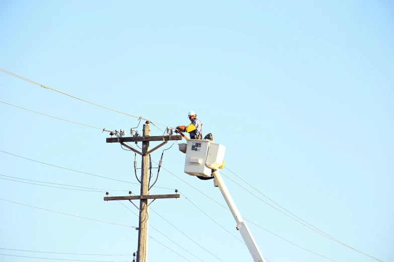 the electric man is on his ladder repairing wires