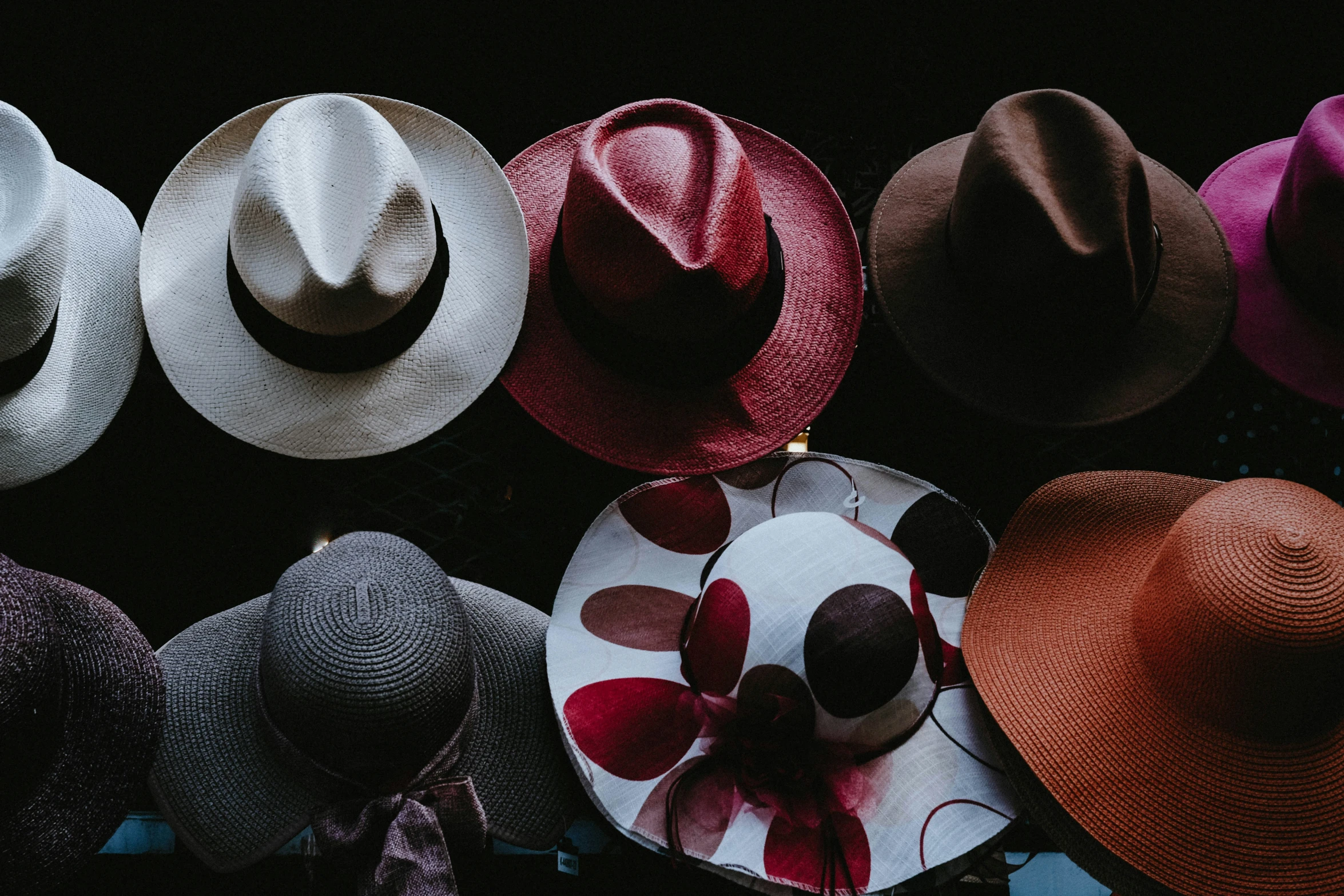 a collection of hats, one with a flower on top