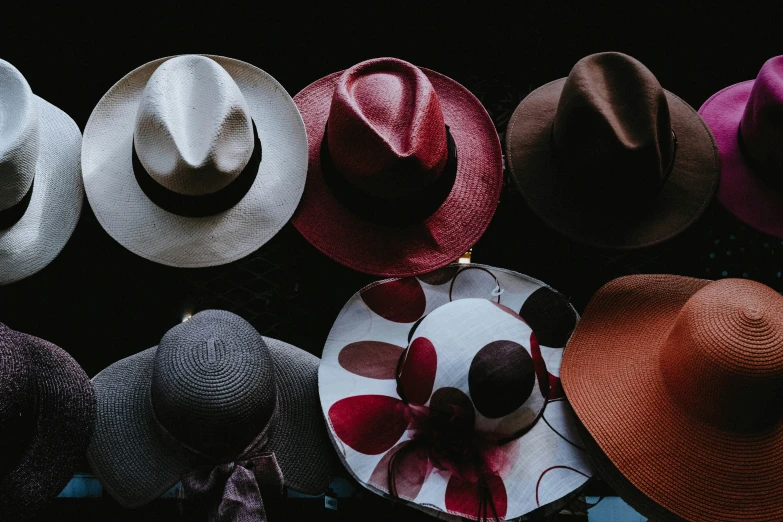 a collection of hats, one with a flower on top