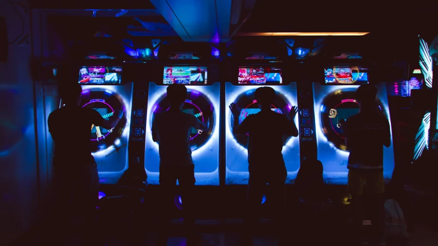 three people standing in front of some machines at night