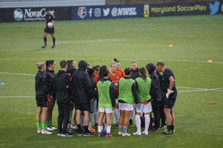 a soccer team is huddling around in the rain