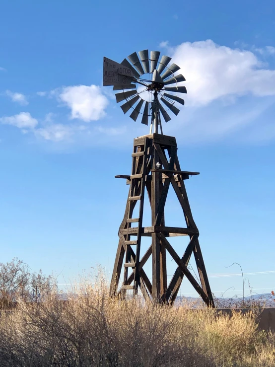 an old wind powered farm windmill in a field