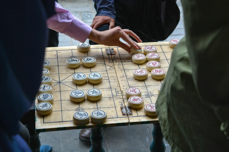 a person moves a wooden board game that is made from cardboard