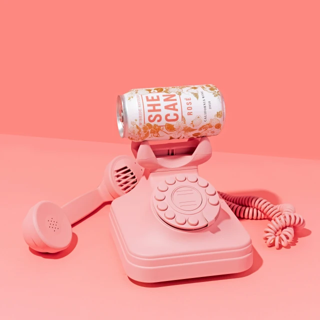 a pink phone is being opened next to an empty bottle