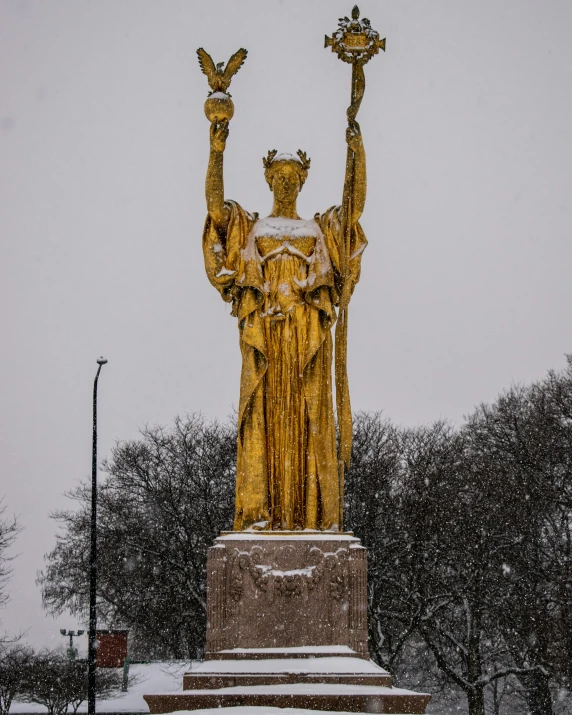 a statue is adorned with gold in the winter