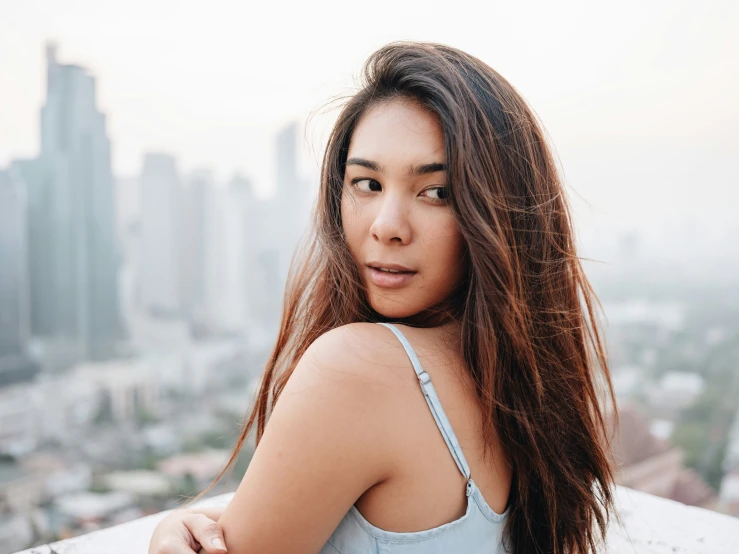 a woman posing in front of a city skyline