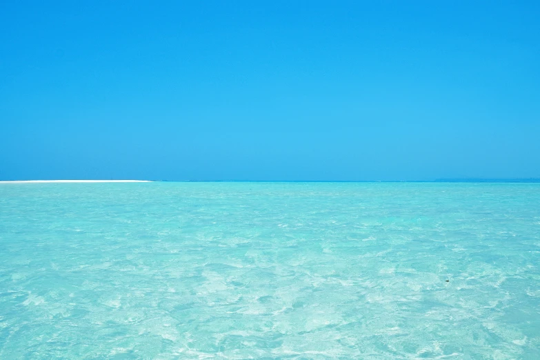 a boat sailing in the water on an open beach