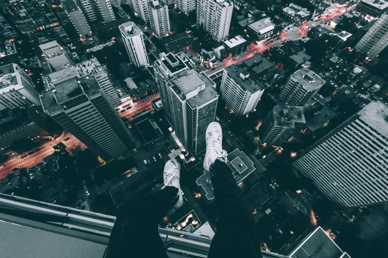 a person standing on top of a tall building looking down at a city