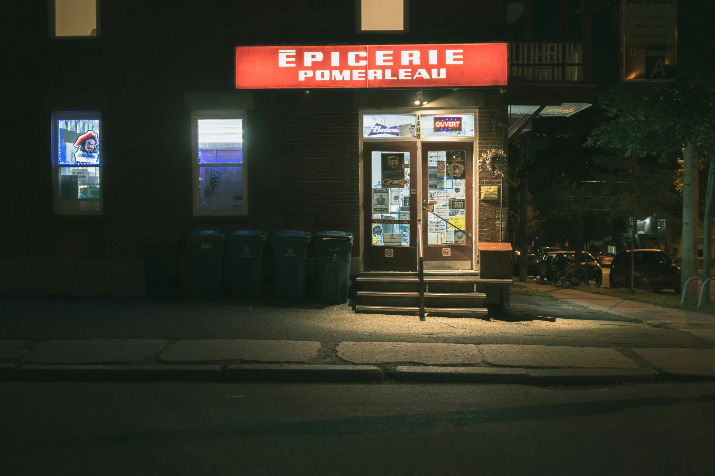a dark city street at night with the words epilerie primenelaire on the side