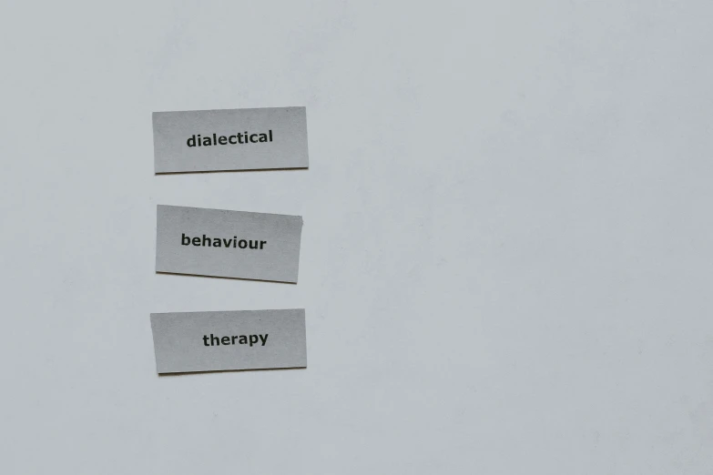 three labels sitting on top of a white wall