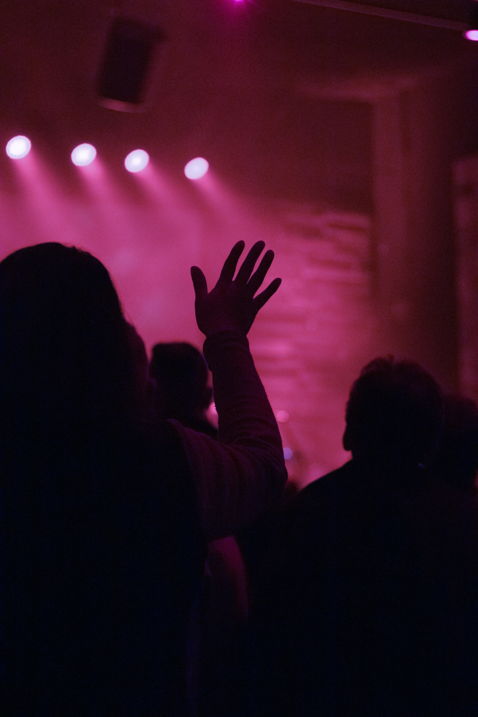 a stage full of people raising their hands up