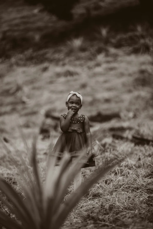 black and white pograph of child in field with bush