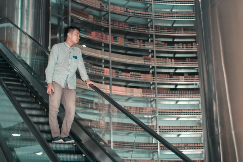 the man in jeans is walking down an escalator