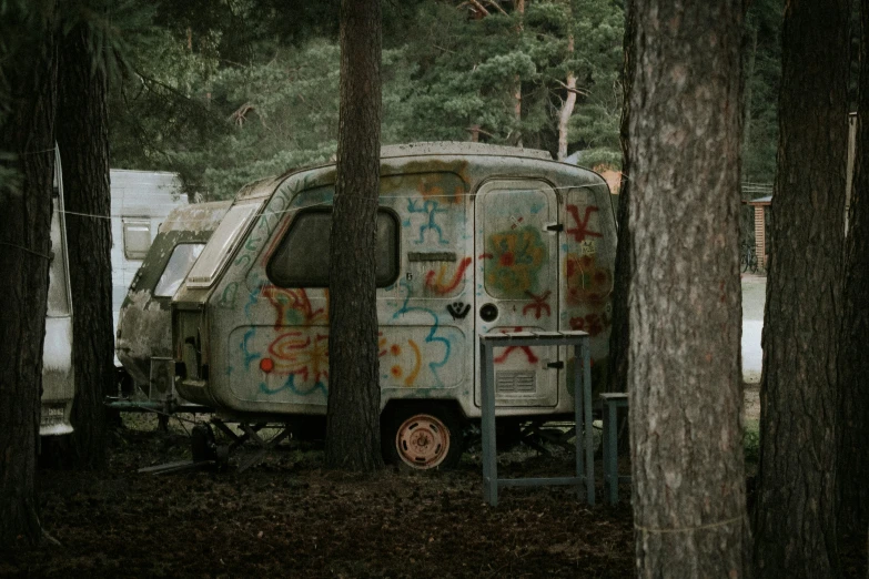 the camper is parked in the wooded area