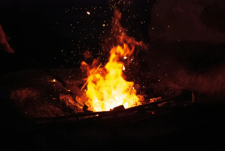 a glowing orange fire at night in the dark