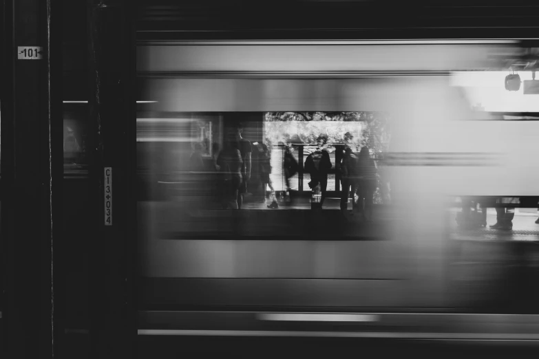 black and white pograph of people standing on a train