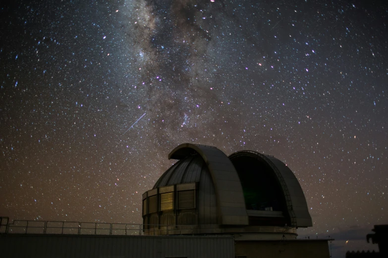the milky hangs over the top of an observatory