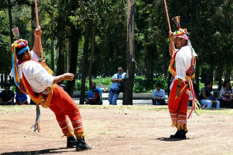 some men in colorful outfits playing with sticks