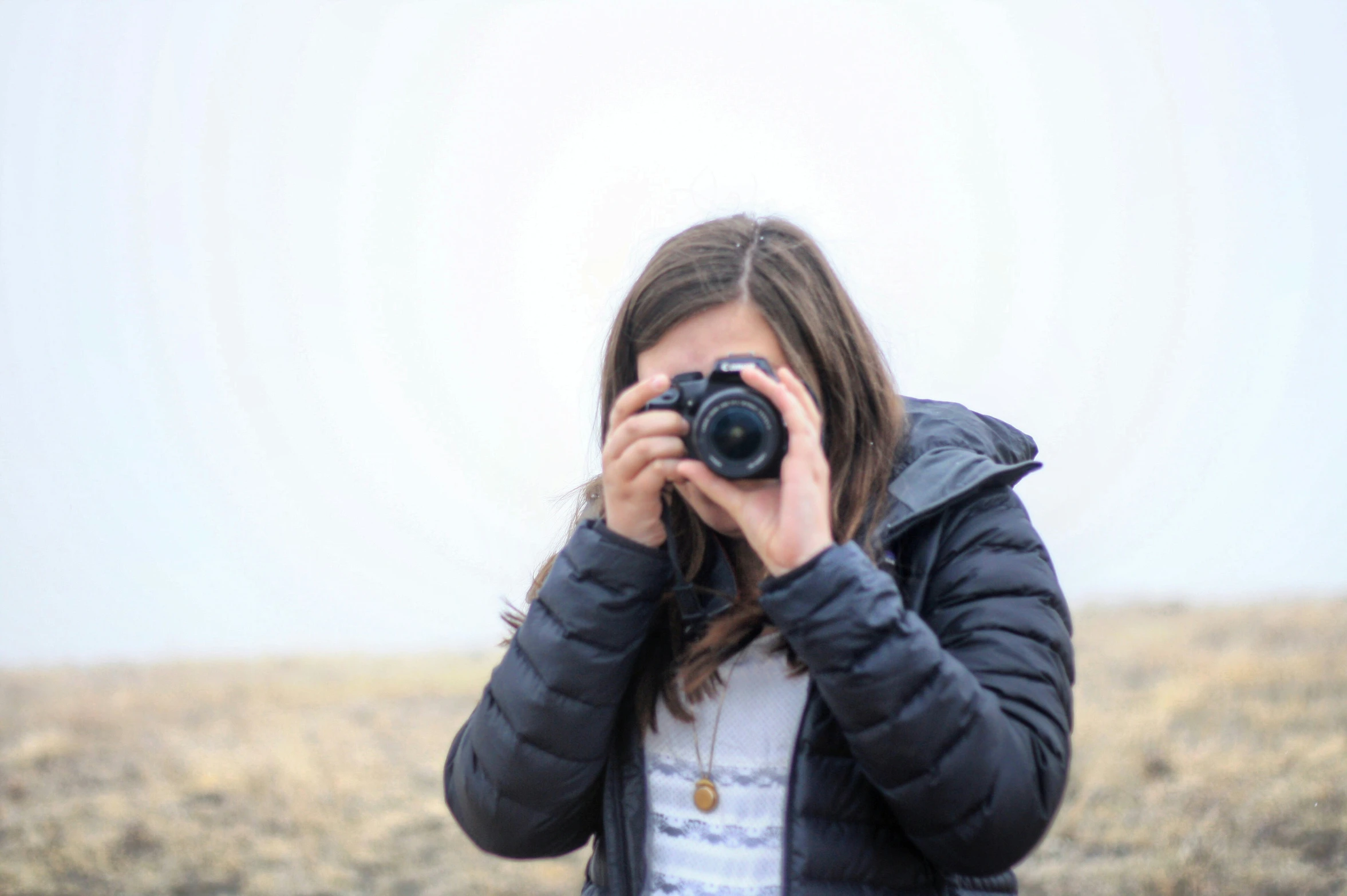 a woman holding up a camera in front of her