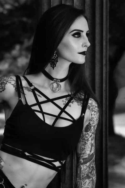 a woman in a black top with tattoos standing