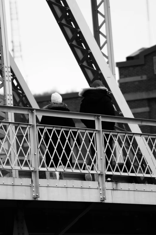 a black and white po shows a man on a bridge, holding a baseball in one hand and a ball in the other hand