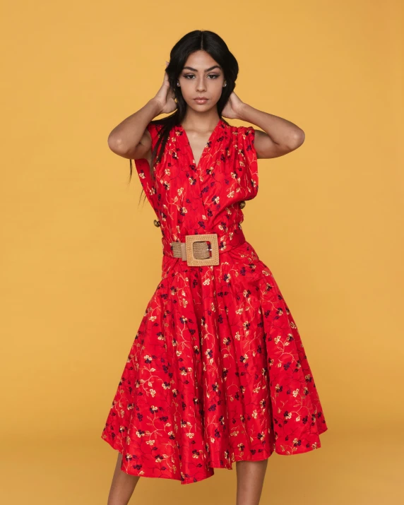 a woman poses for a po in a red and black dress