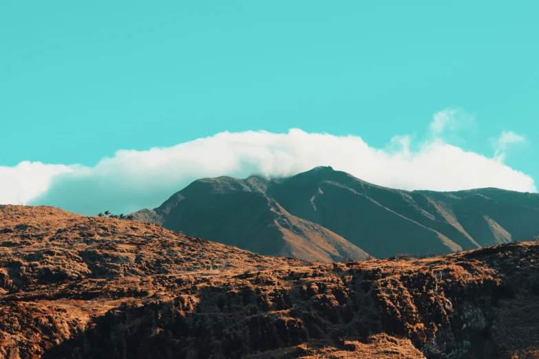 a rocky mountain range with clouds in the sky