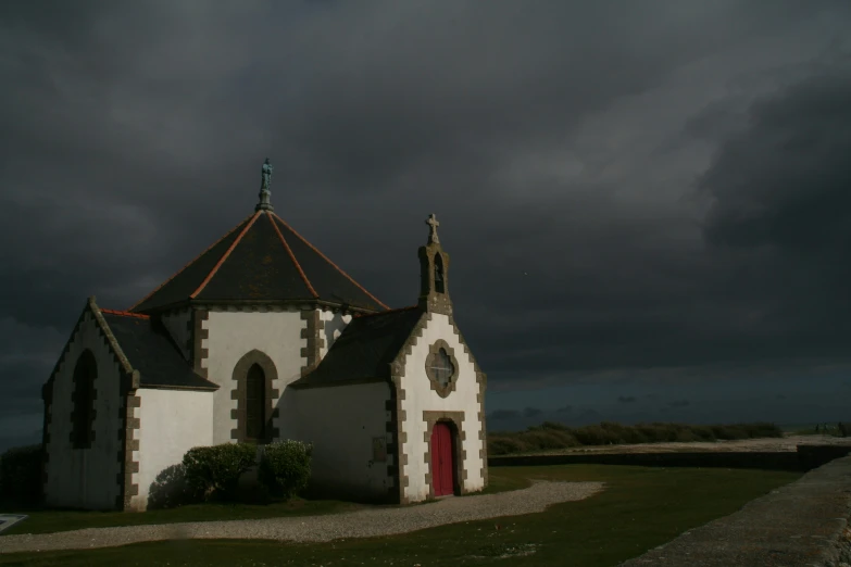 a white and brown church with a red door and red door