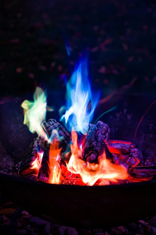 a fire is lit in the dark with colorful flames