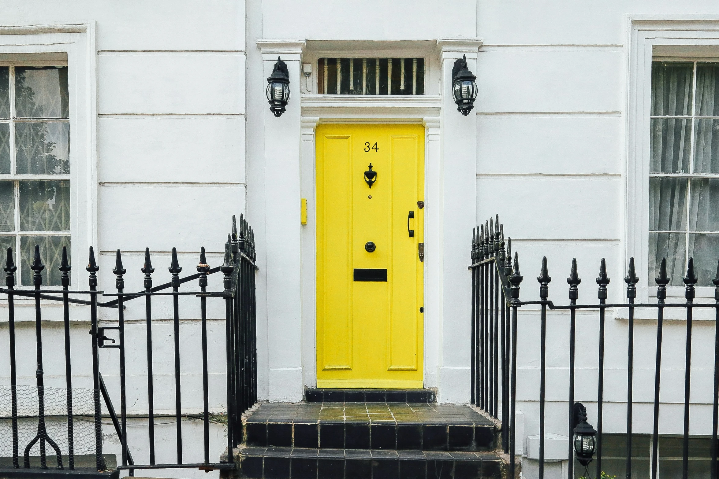 a house with a yellow door near some windows